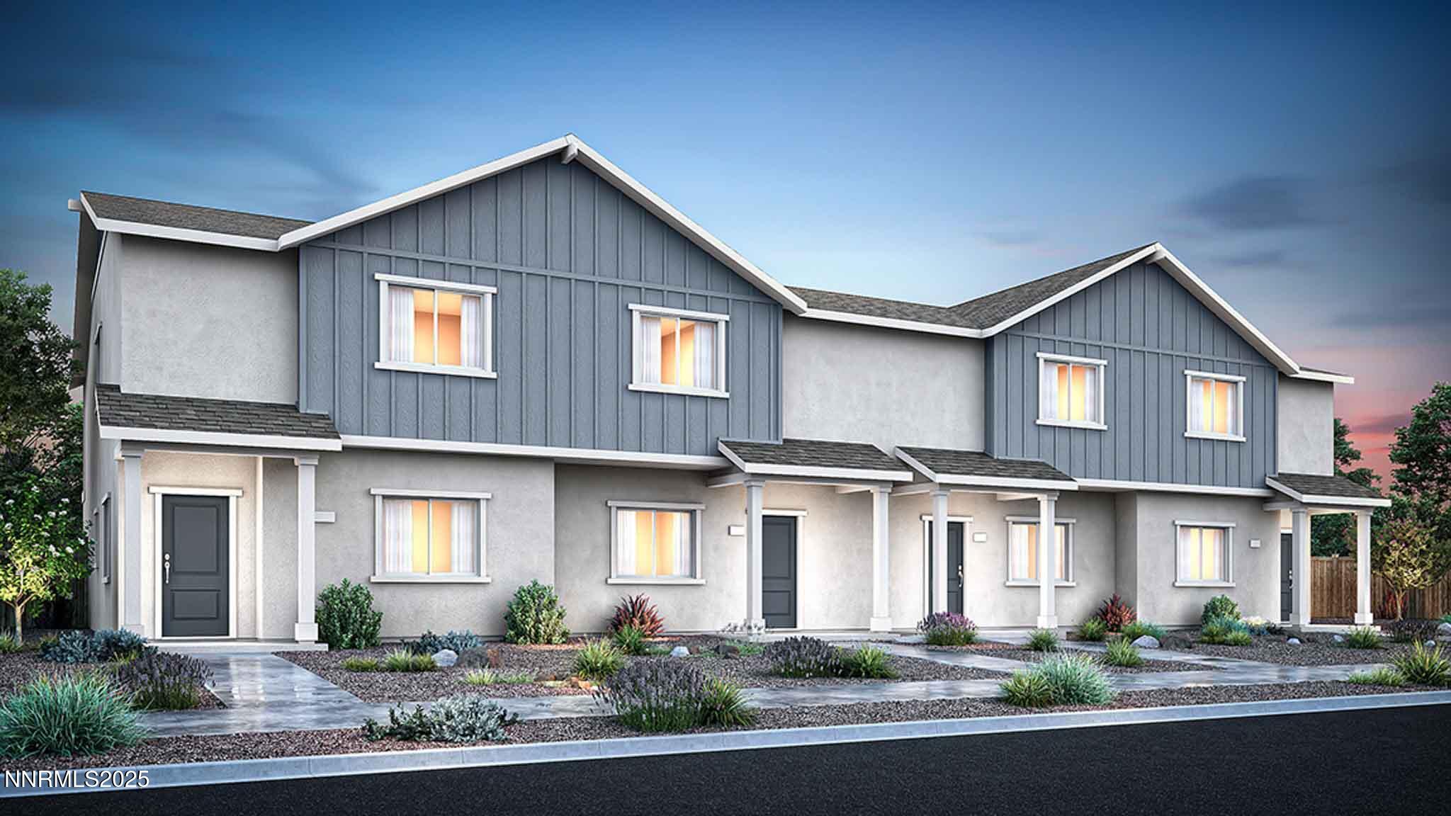 a front view of a house with garage and plants