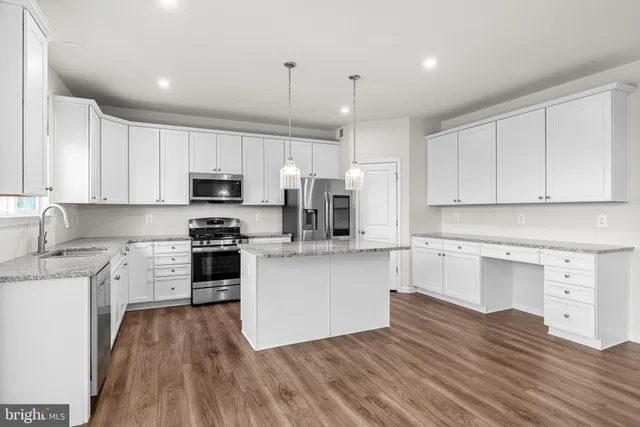 a kitchen with cabinets wooden floor and a sink