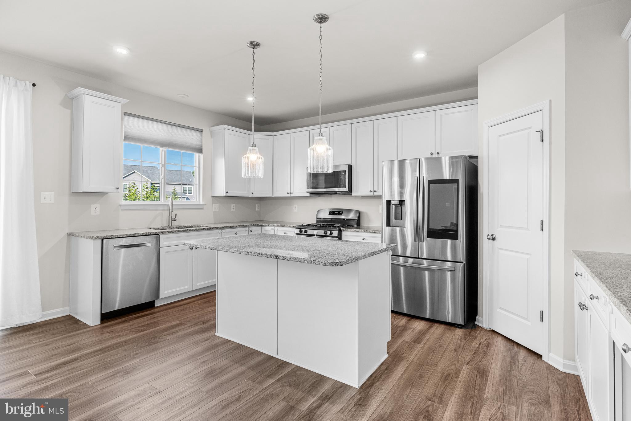 1022 Fawn Haven Walk Dover, DE 19901 - Photo 12 of 46 a kitchen with stainless steel appliances granite countertop a refrigerator a sink dishwasher a stove and white countertops with wooden floor