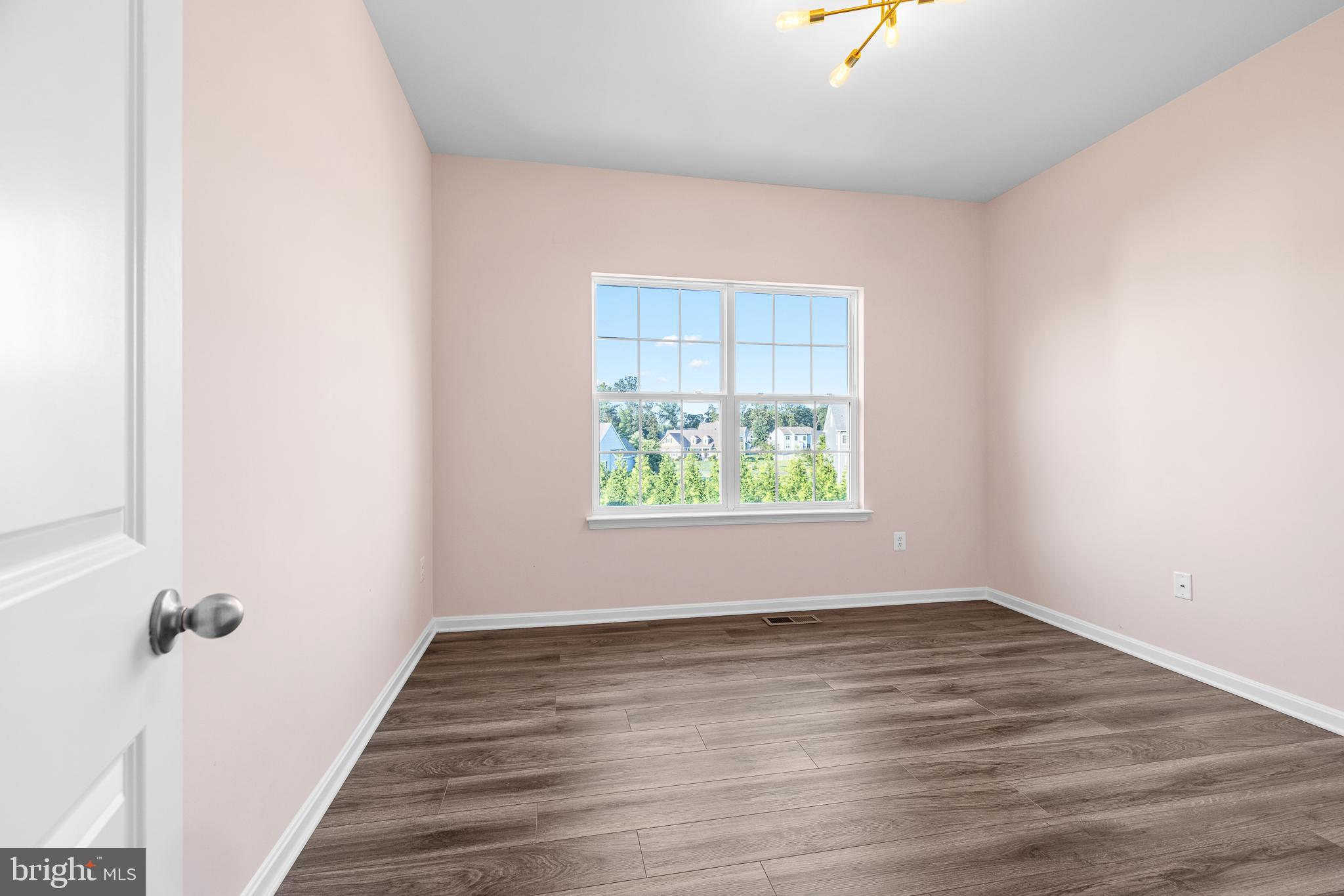 1022 Fawn Haven Walk Dover, DE 19901 - Photo 20 of 46 a view of an empty room with wooden floor and a window