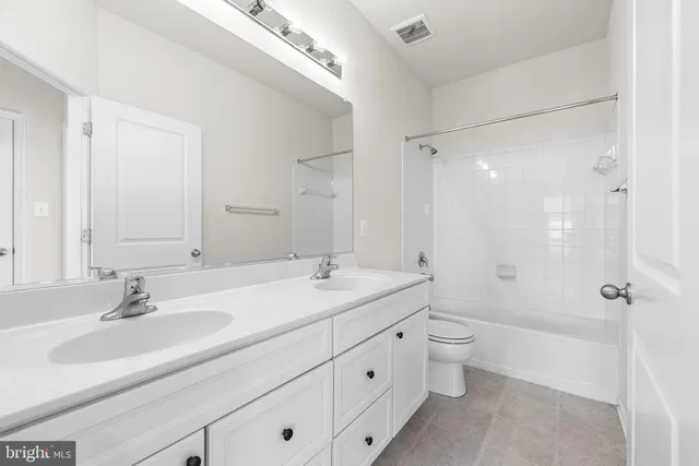 a bathroom with a double vanity sink toilet mirror and shower