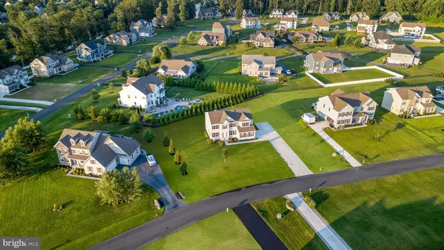 an aerial view of a tennis ground and a cars park side of the road