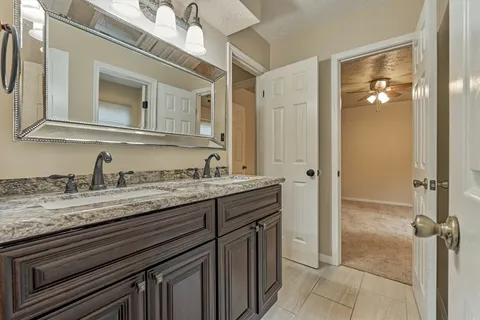 a bathroom with a granite countertop sink and a mirror