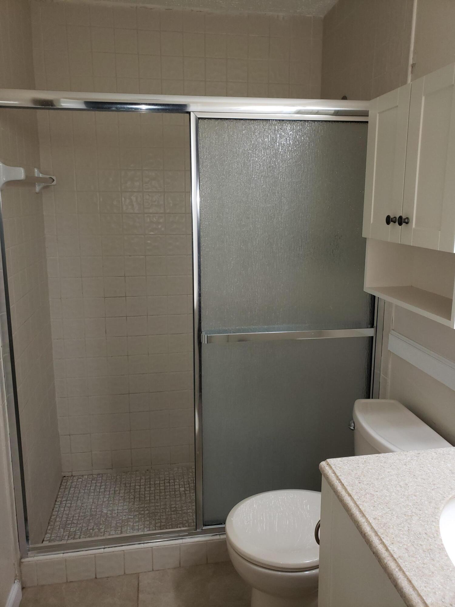 5673 Biscayne Drive Greenacres, FL 33463 - Photo 18 of 24 a bathroom with a shower and a toilet