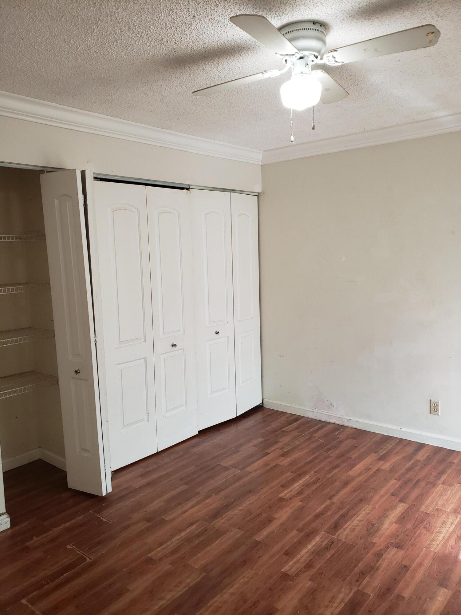 5673 Biscayne Drive Greenacres, FL 33463 - Photo 20 of 24 a view of an empty room with wooden floor