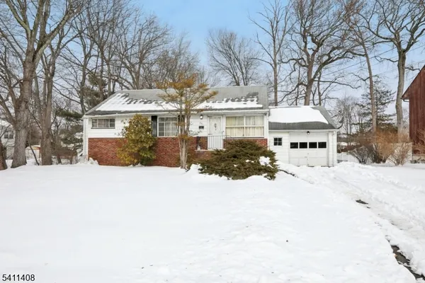 a front view of a house with a yard covered in snow