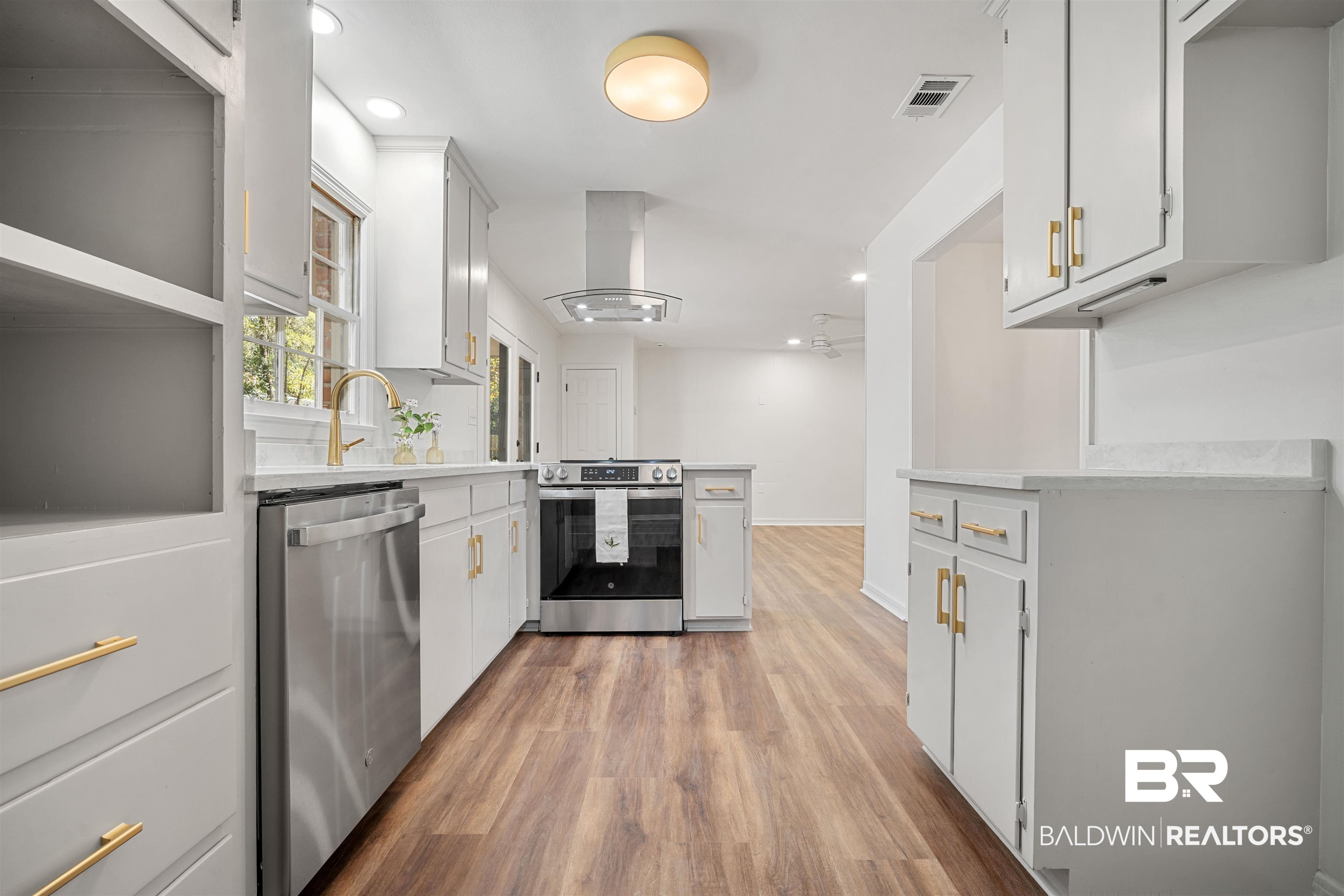 Kitchen with white cabinetry, stainless steel appliances, island range hood, recessed lighting, and open shelves