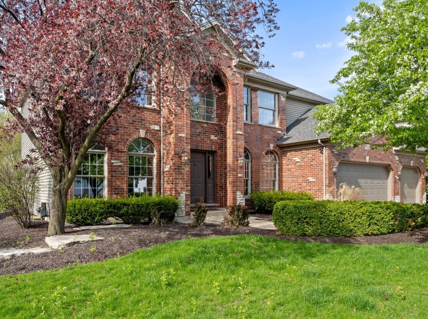 a front view of a house with yard and green space