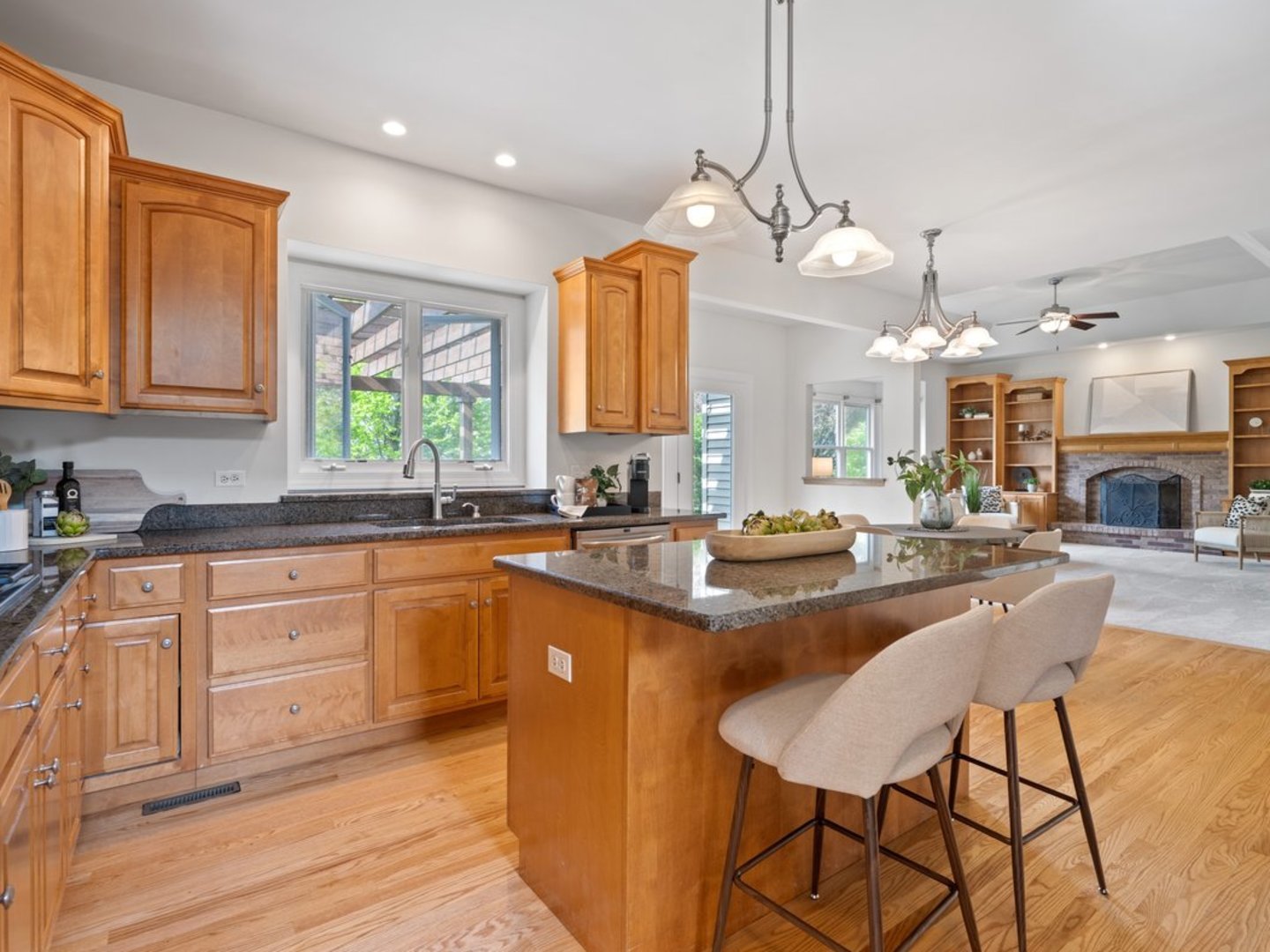 3035 Rollingridge Road Naperville, IL 60564 - Photo 7 of 28 a kitchen with stainless steel appliances granite countertop a stove top oven a sink a dining table and chairs with wooden floor