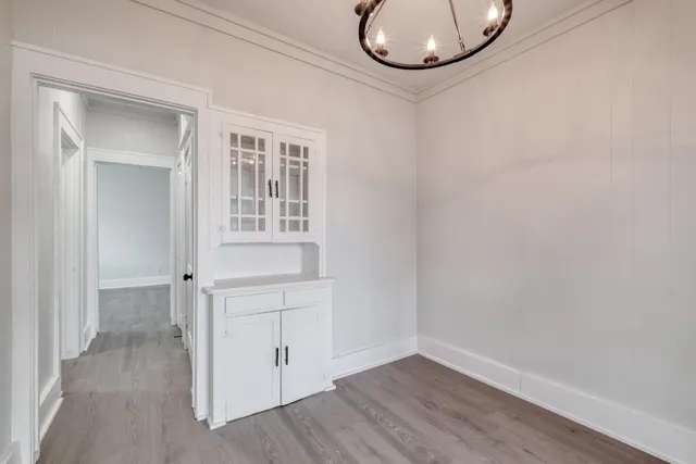 an empty room with wooden floor and mirror