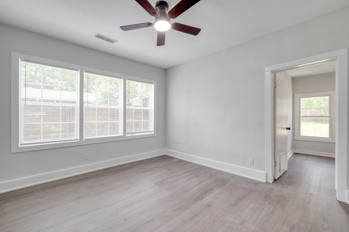 7406 Bethune Avenue Austin, TX 78752 - Photo 12 of 38 a view of an empty room with a window and wooden floor