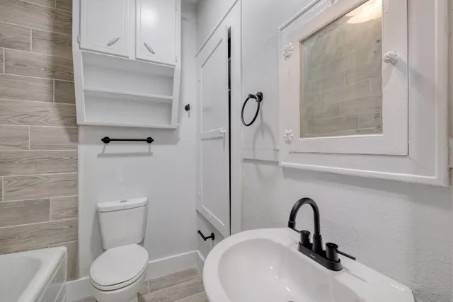a bathroom with a sink toilet and a mirror