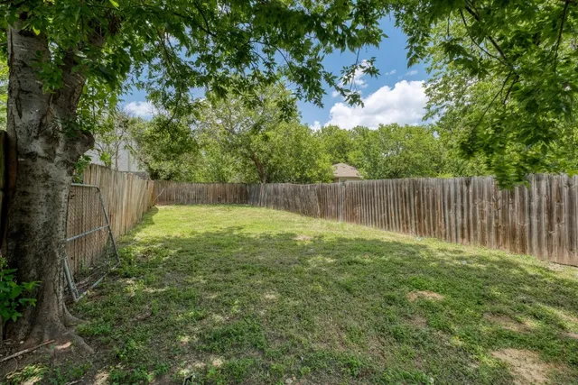 a view of garden with wooden fence