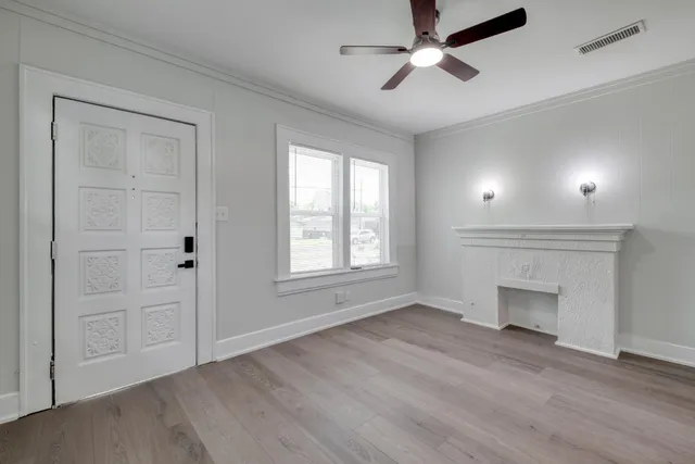 a view of an empty room with a fireplace and a window