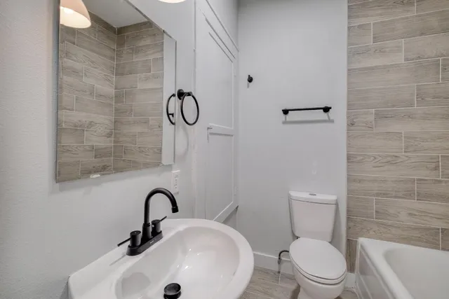 a bathroom with a toilet a sink and mirror