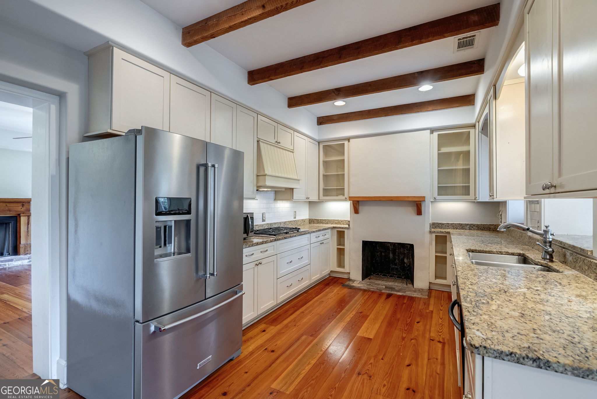 1761 Farmington Road Madison, GA 30650 - Photo 12 of 61 a kitchen with granite countertop stainless steel appliances and wooden cabinets