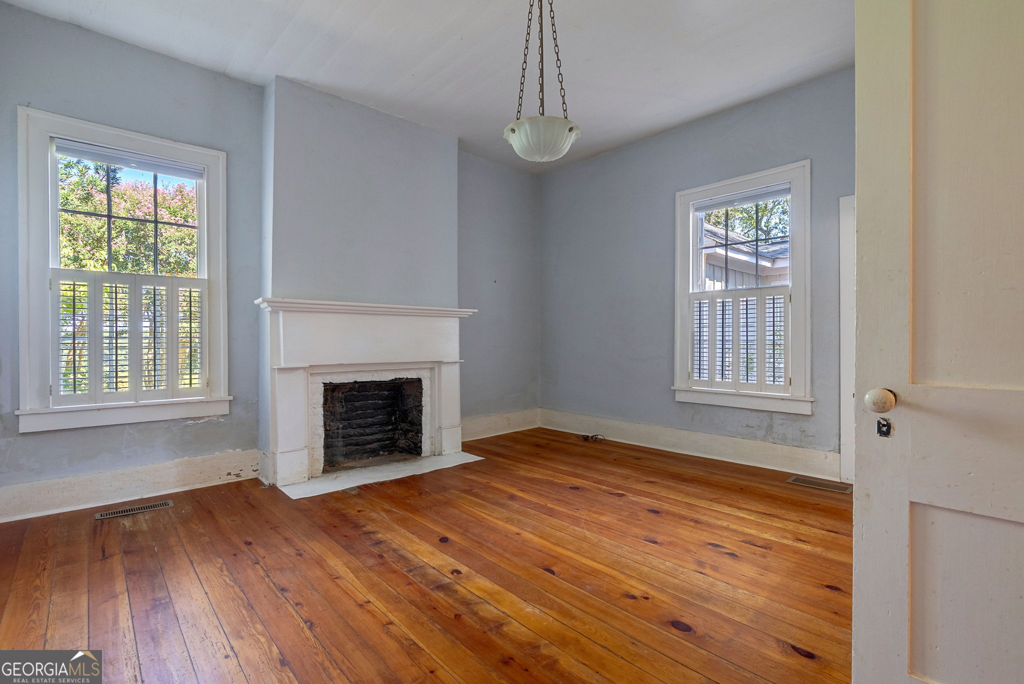 1761 Farmington Road Madison, GA 30650 - Photo 8 of 61 a view of an empty room with wooden floor fireplace and a window