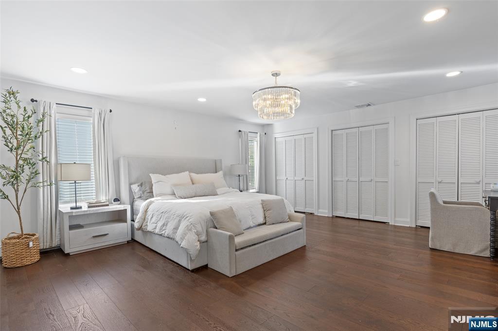 11 Robin Hood Way Wayne, NJ 07470 - Photo 21 of 36 a spacious bedroom with a bed and a chandelier