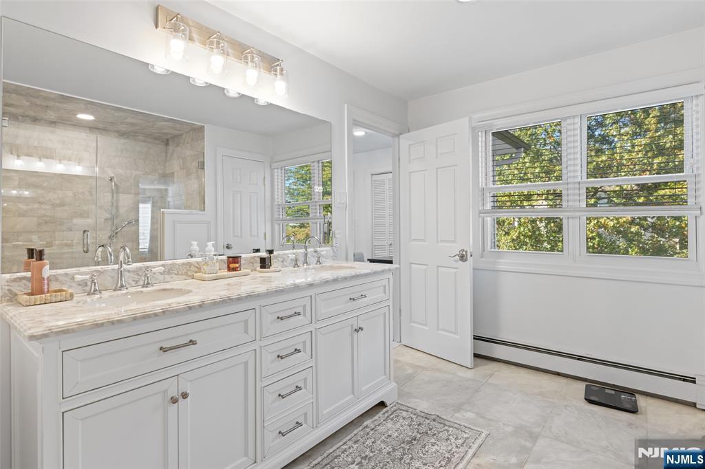 11 Robin Hood Way Wayne, NJ 07470 - Photo 23 of 36 a bathroom with a granite countertop sink mirror and next to a window