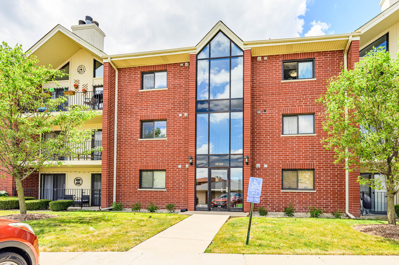 18136 Rita Road, Unit 1D Tinley Park, IL 60477 - Photo 1 of 11 a view of a brick house with many windows and a yard