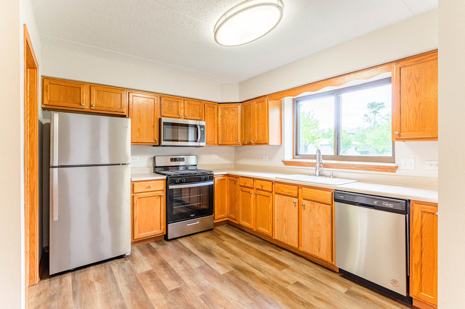 18136 Rita Road, Unit 1D Tinley Park, IL 60477 - Photo 4 of 11 a kitchen with stainless steel appliances granite countertop a refrigerator stove top oven and sink