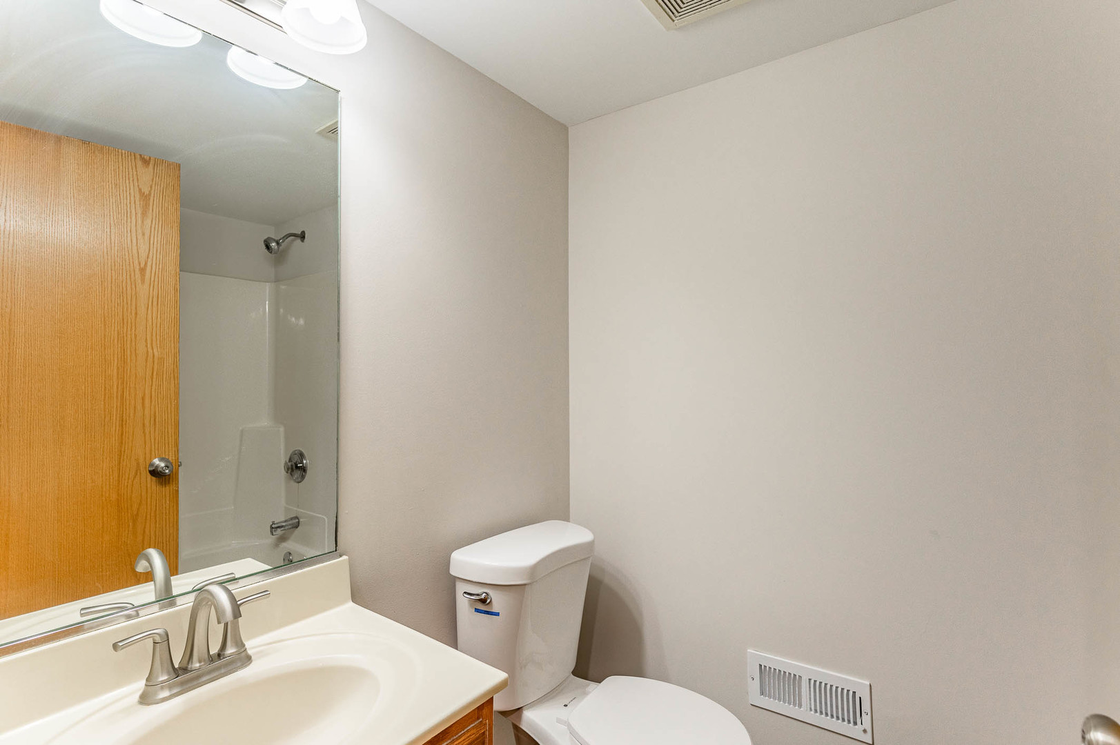 18136 Rita Road, Unit 1D Tinley Park, IL 60477 - Photo 9 of 11 a bathroom with a toilet a sink and mirror
