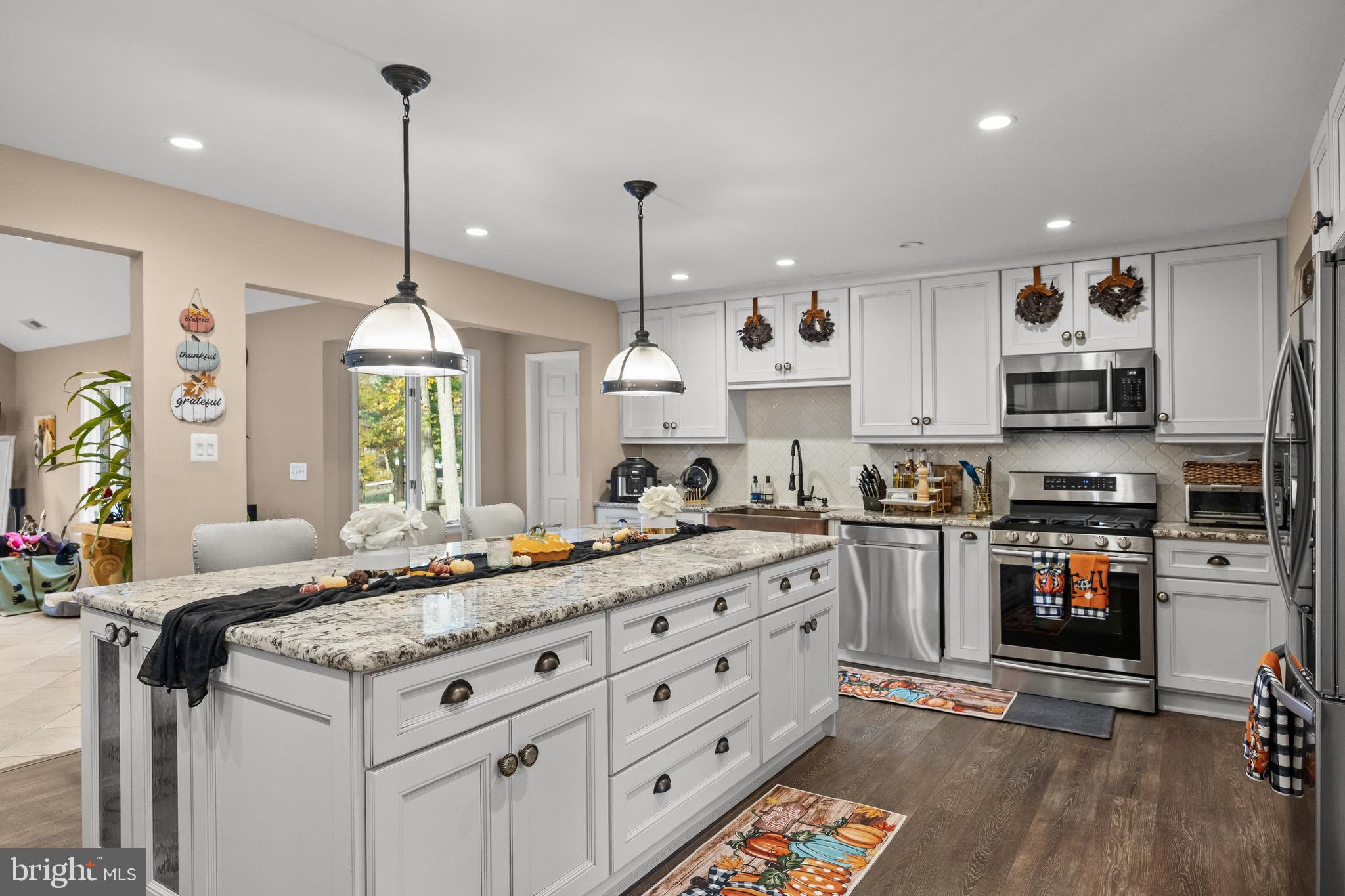 155 Tuckerton Road Medford Lakes, NJ 08055 - Photo 13 of 48 a kitchen with stainless steel appliances kitchen island granite countertop a sink a stove and a wooden floors