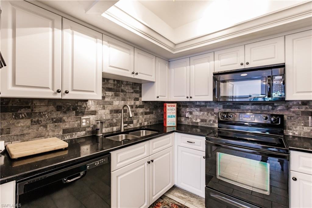 Undisclosed Address Naples, FL 34113 - Photo 8 of 24 a kitchen with granite countertop white cabinets and black appliances