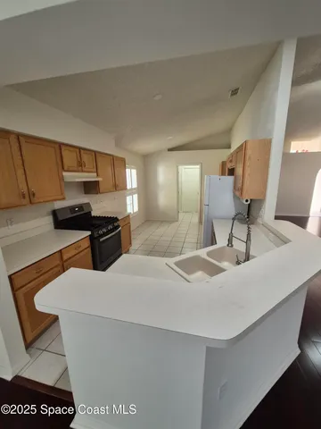 a living room with a sink a counter space and a window