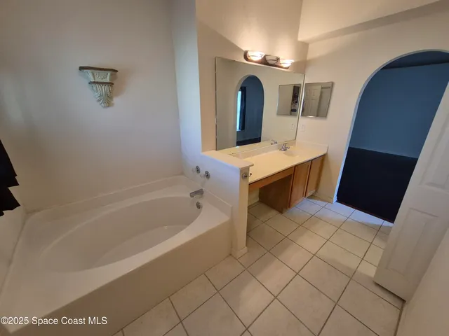 a bathroom with a tub sink and mirror