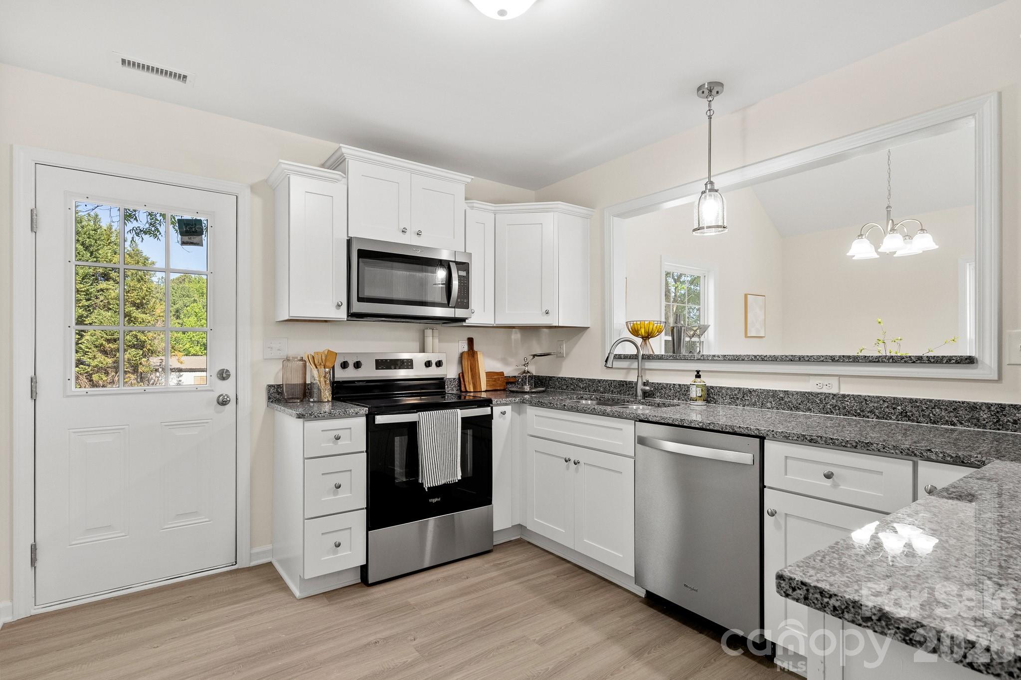 805 Hunter Street York, SC 29745 - Photo 11 of 38 a kitchen with stainless steel appliances granite countertop a sink a stove and a wooden floors