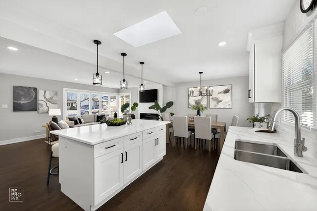 a kitchen with counter top space sink stove and wooden floor