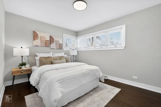 a bedroom with a bed and a painting on the wall