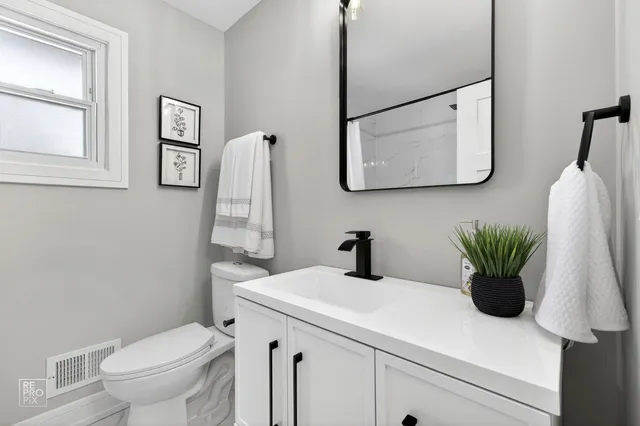 a bathroom with a sink a toilet and mirror