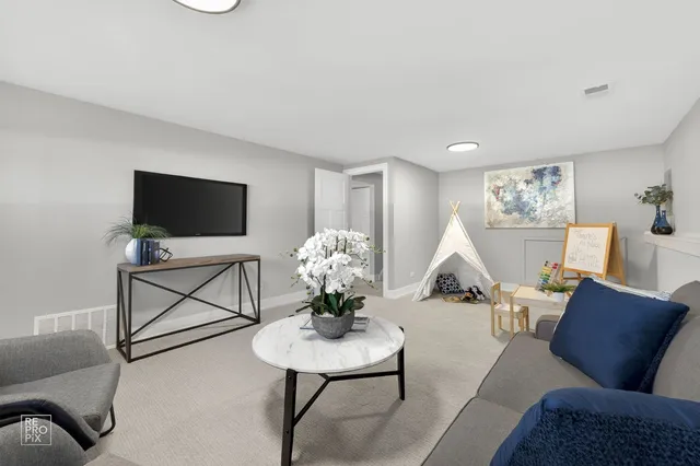 a living room with furniture a flat screen tv and a dining table