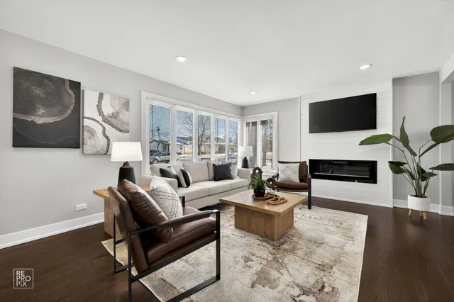 a living room with furniture a flat screen tv and a fireplace
