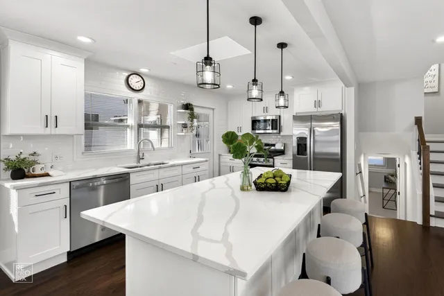 a kitchen with stainless steel appliances kitchen island granite countertop a table and chairs in it