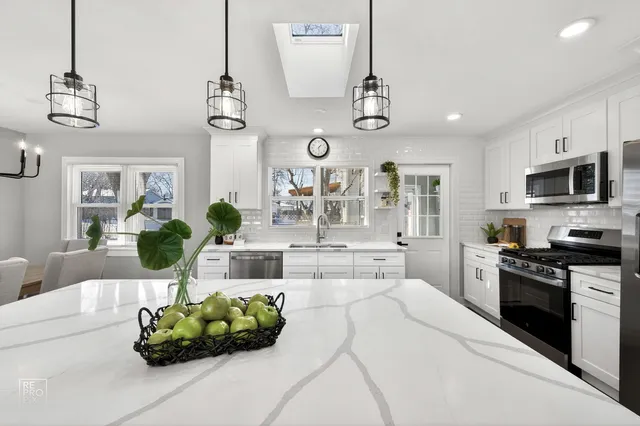 a living room with furniture kitchen view and a chandelier