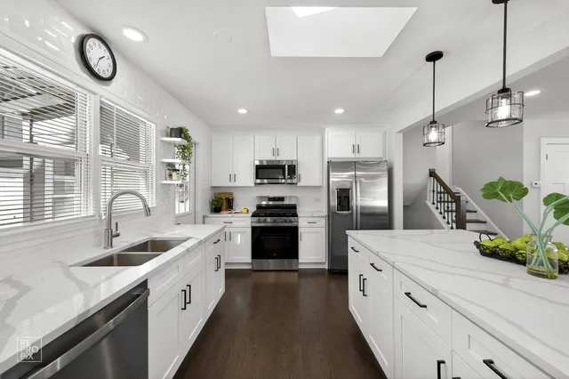 a kitchen with white cabinets and stainless steel appliances