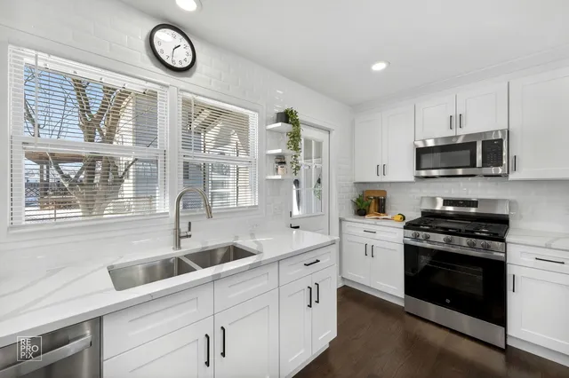 a kitchen with stainless steel appliances a stove a sink a stove and a microwave