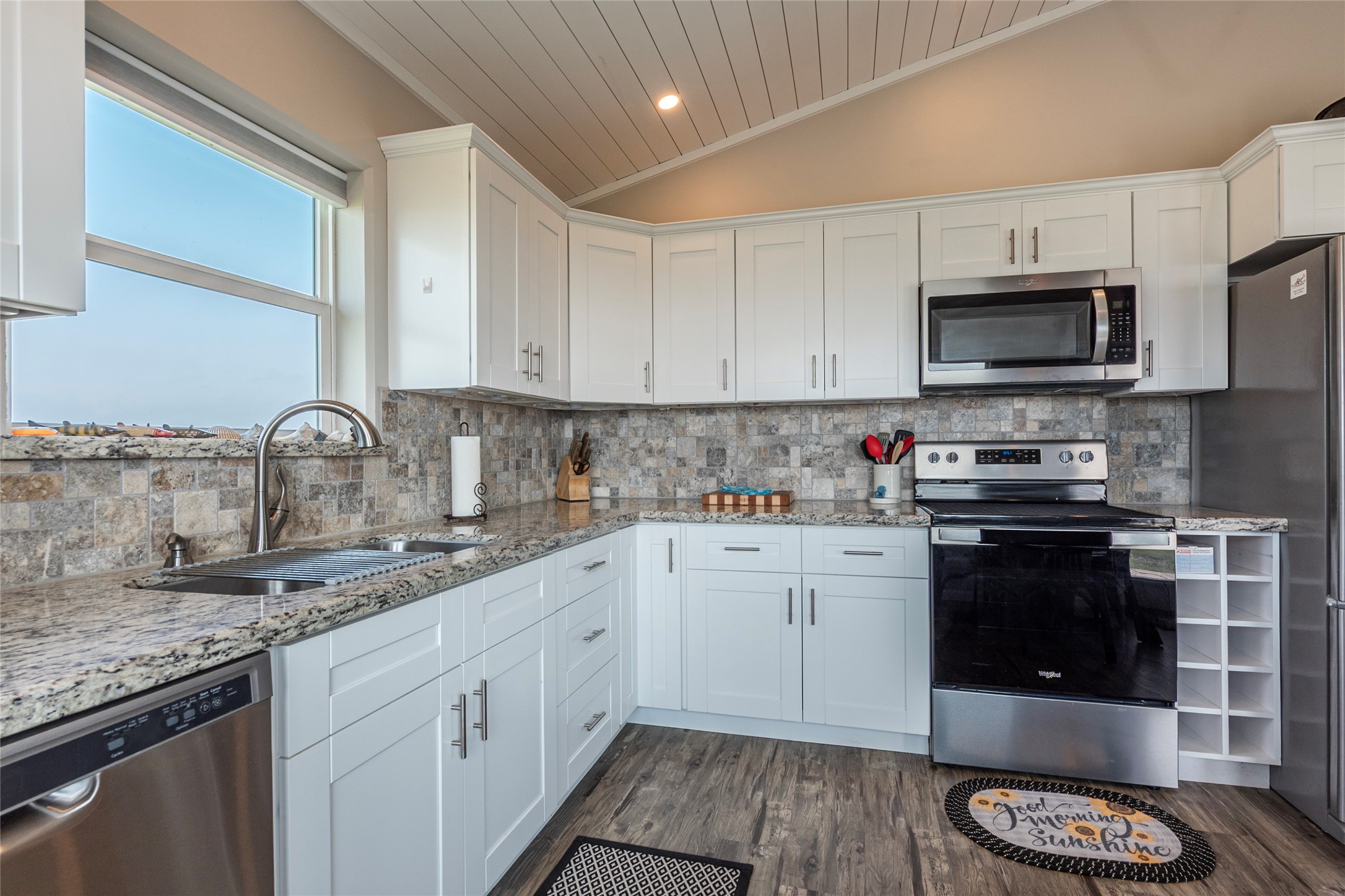 1453 County Road 230 Sargent, TX 77414 - Photo 7 of 30 a kitchen with granite countertop a sink stainless steel appliances and white cabinets