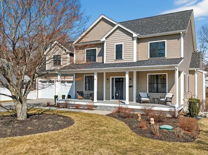 a view of a white house with large windows and a tree