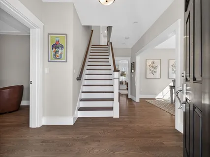 a view of a livingroom with wooden floor and stairs