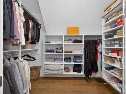 a view of walk in closet with clothes and shoes