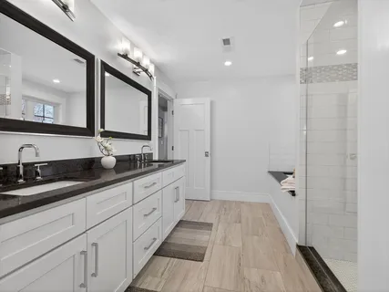 a bathroom with double vanity and a mirror
