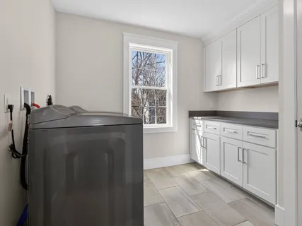 a kitchen with white cabinets and a refrigerator