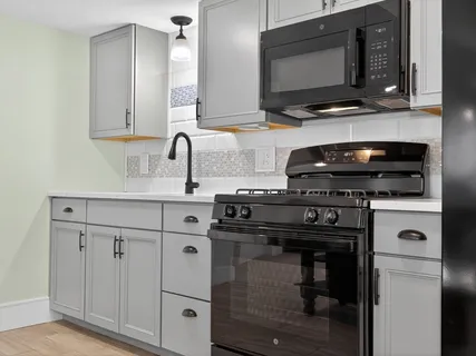 a kitchen with stainless steel appliances a stove microwave and sink