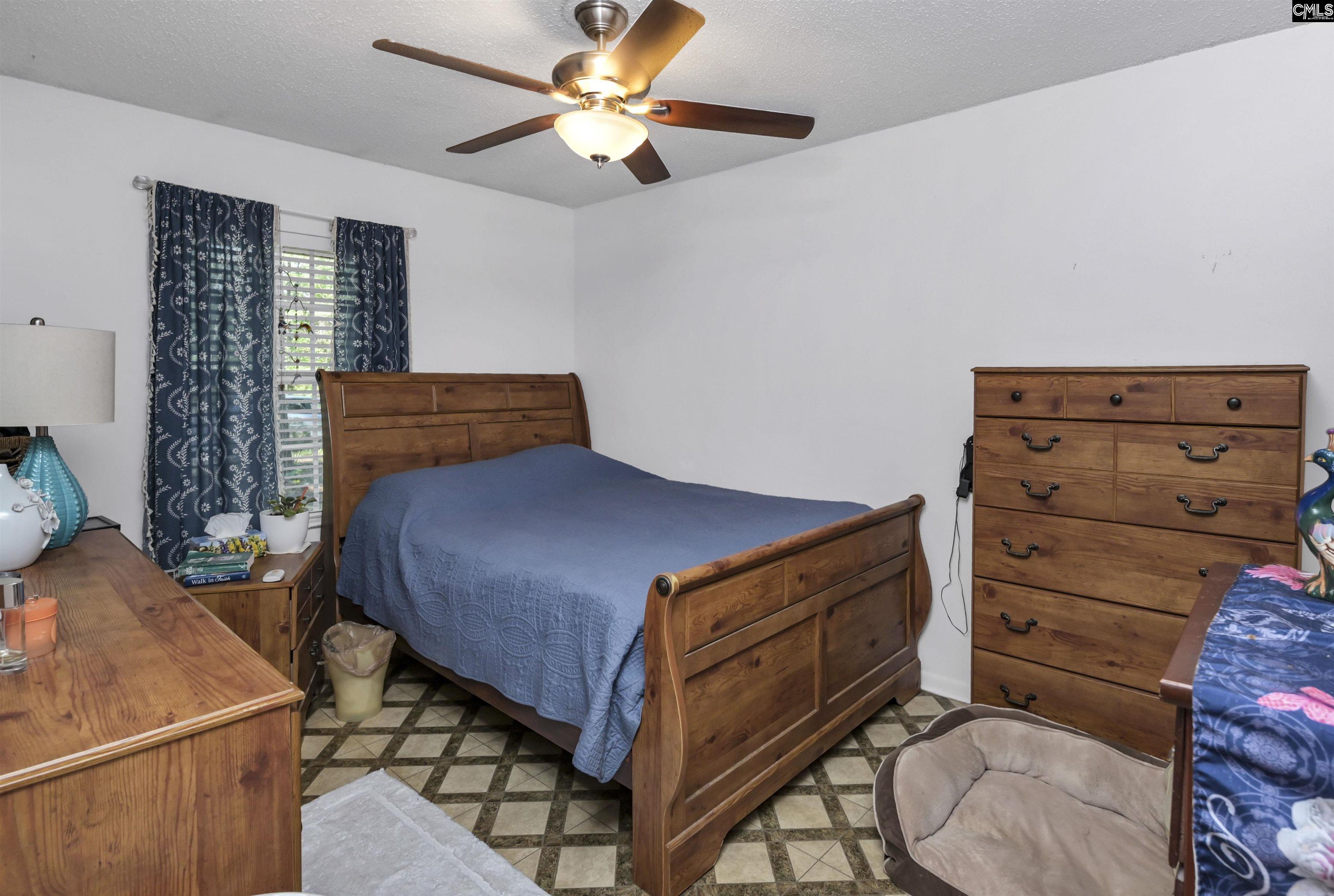 133 Sunset Strip Elgin, SC 29045 - Photo 16 of 30 a bedroom with a bed and a chandelier