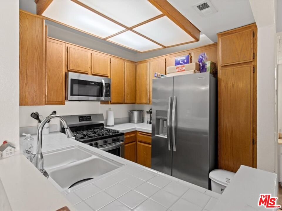 19009 Sherman Way, Unit 2 Reseda, CA 91335 - Photo 13 of 31 a kitchen with stainless steel appliances granite countertop a refrigerator a stove top oven a sink and dishwasher
