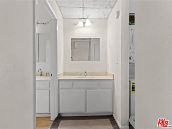 a bathroom with a granite countertop sink a mirror and a shower